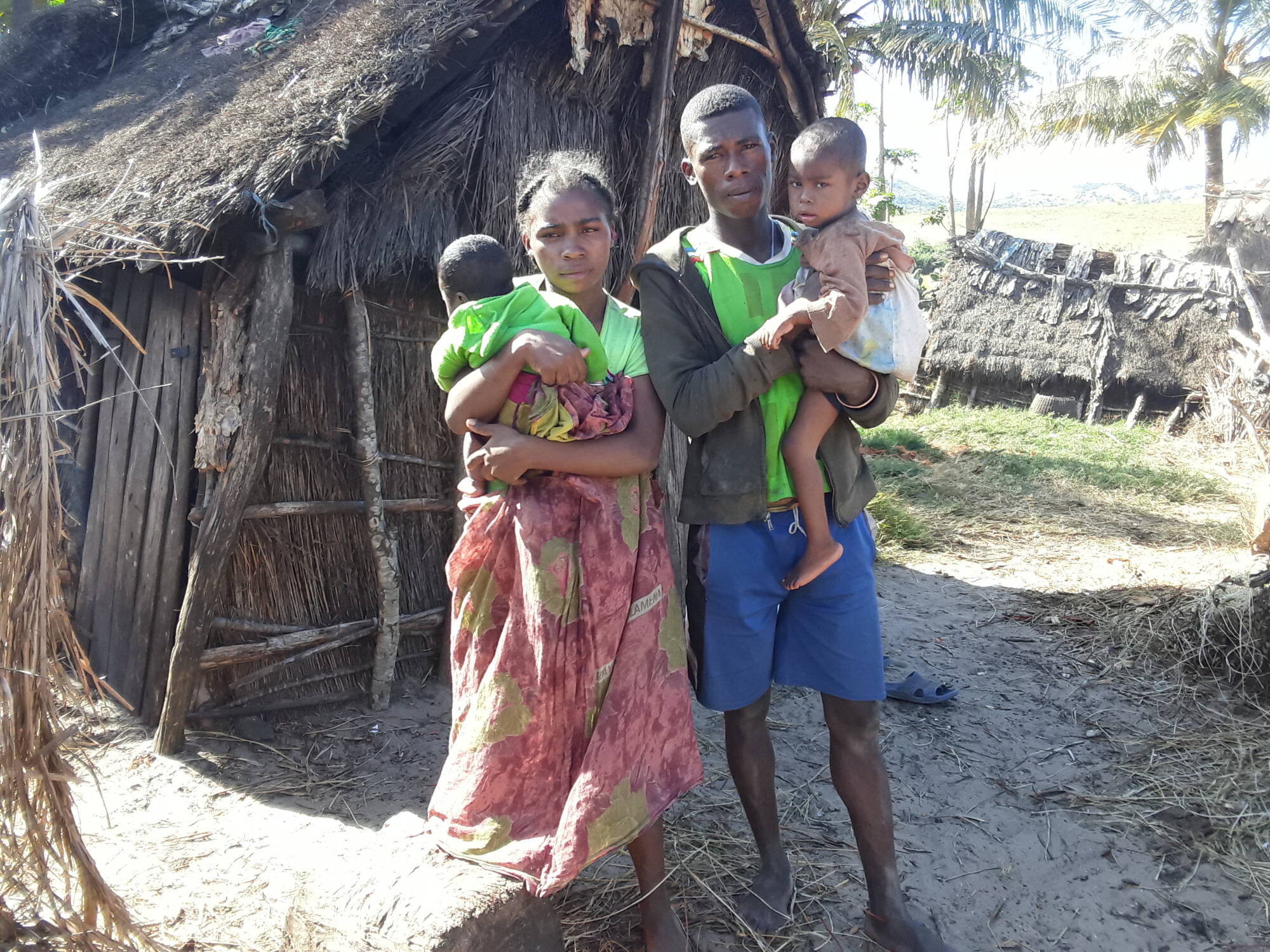 A husband and wife holding their two children