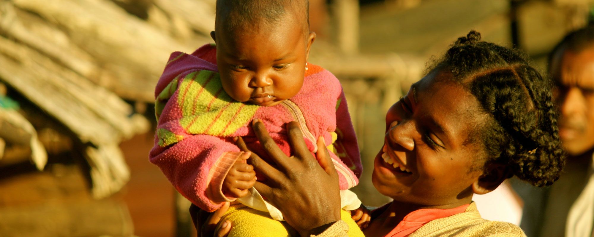 A happy mother holds her baby