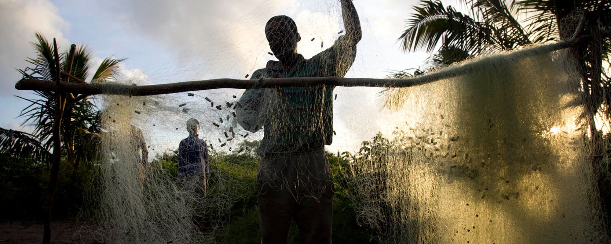 Fisher untangling a net (photo by Ed Kashi)