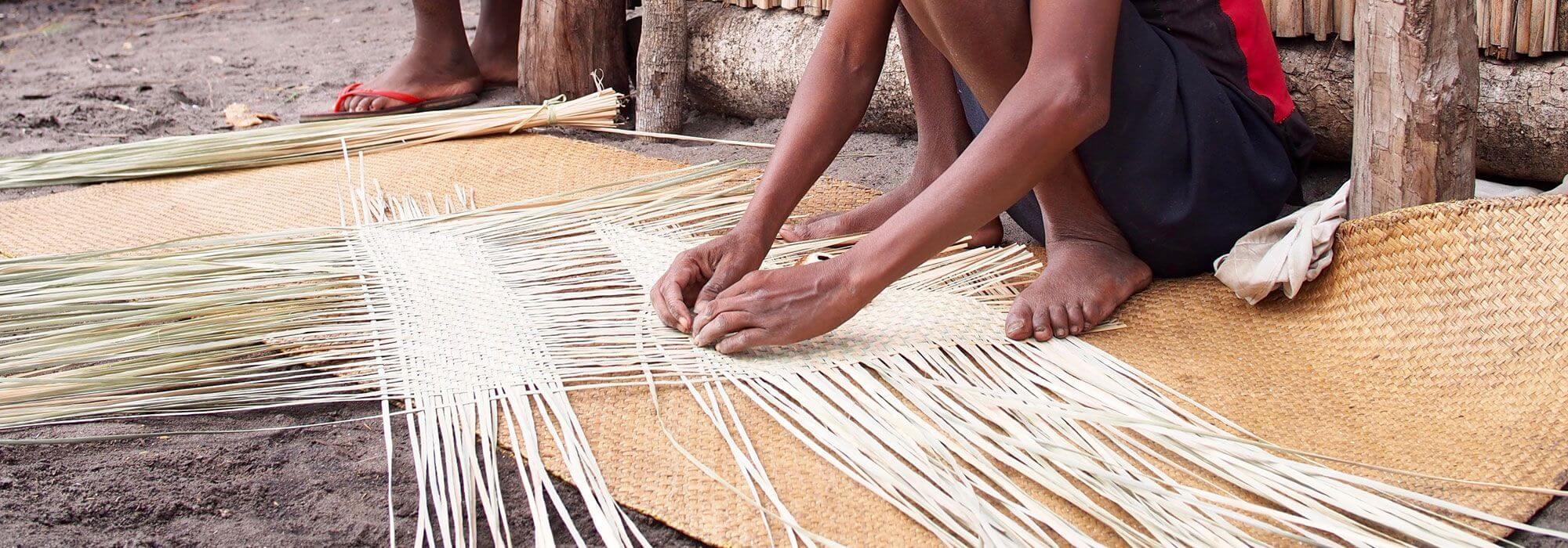 A woman weaver works on a mahampy reed mat