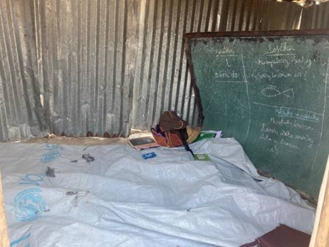 A tin shed with a chalkboard used as a classroom