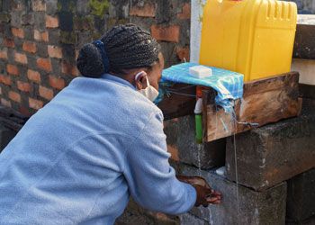 Vayah using the new handwashing system at the SEED office