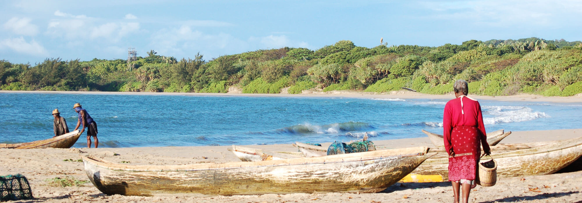 A woman on the beach in Sainte Luce Madagascar, pirogues in the background