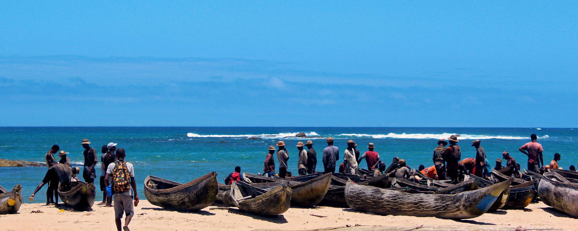 Fishers pull their pirogues ashore after a morning out at sea collecting sharks, lobsters and fish