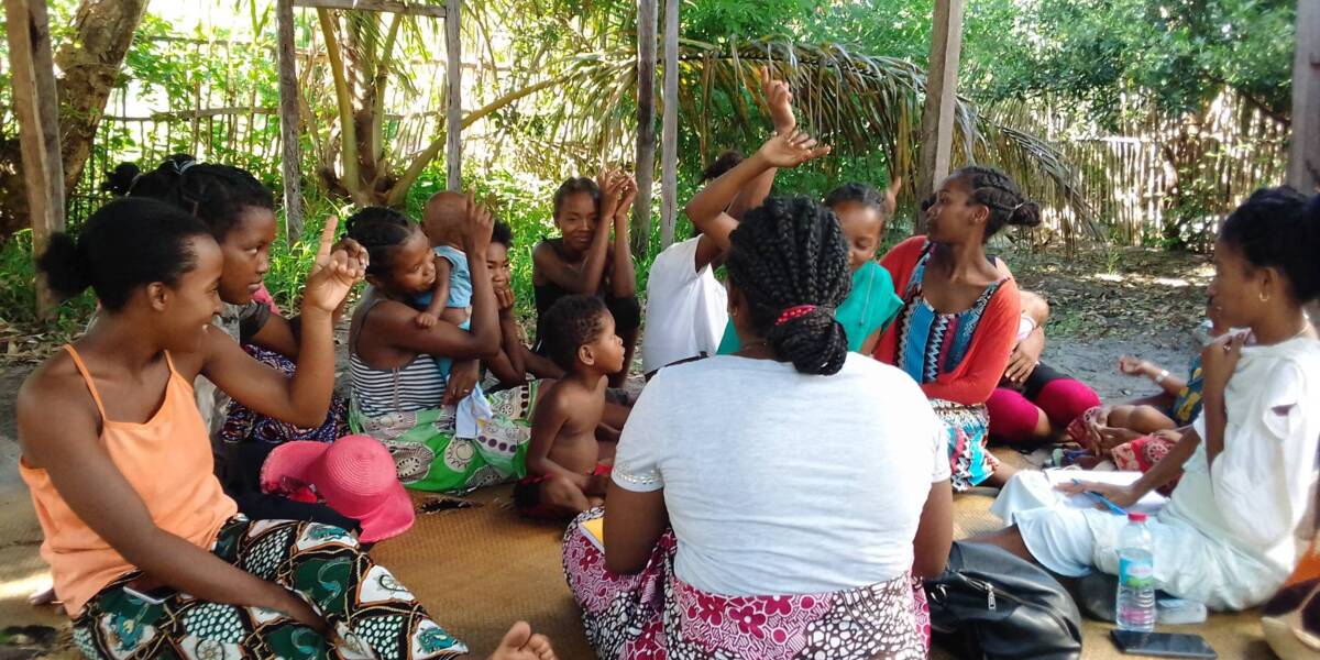 Malagasy women sitting at a Project Votsira community information session