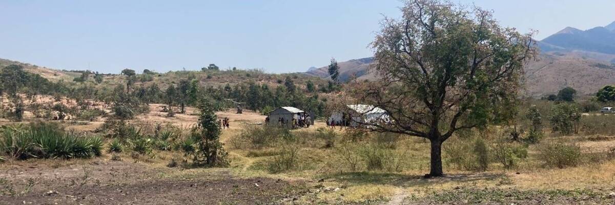 A small school shed and UNICEF school tent sit on dry land