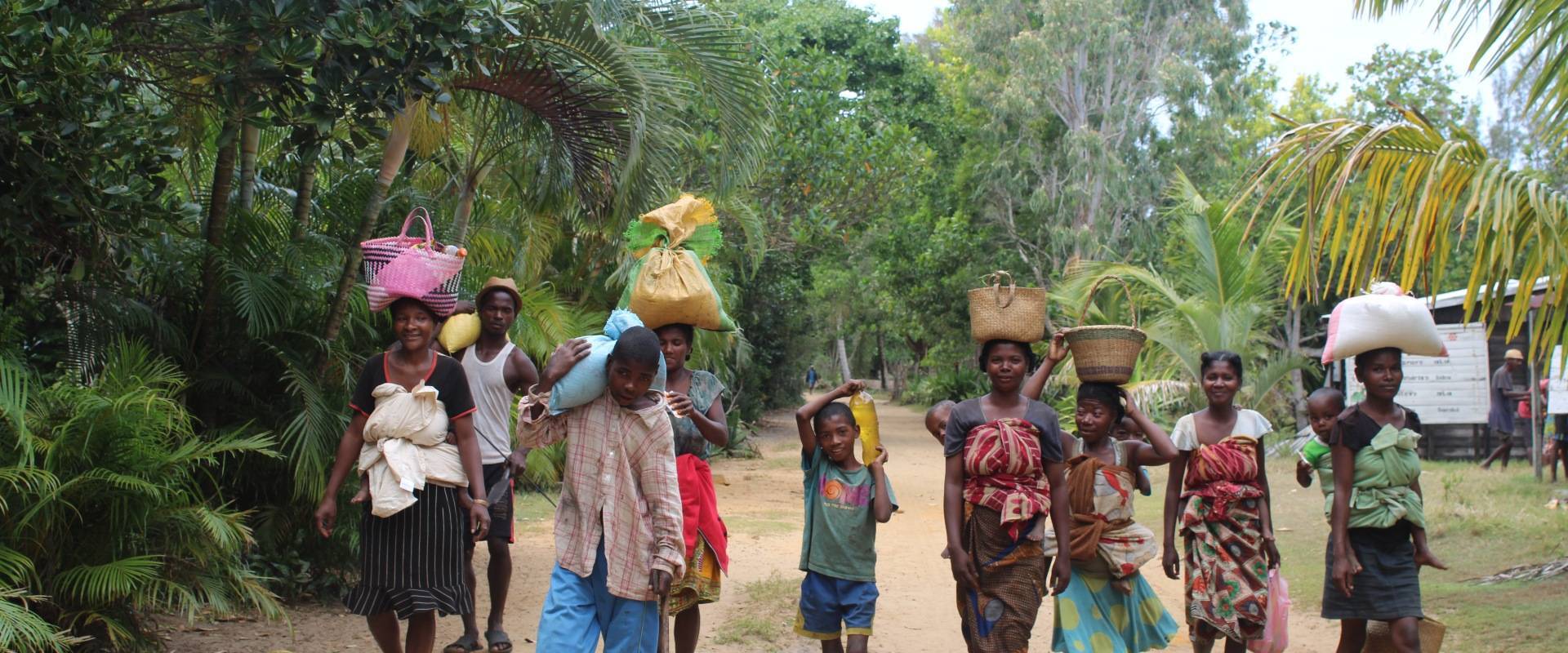 Malagasy people walking and carrying staple food stocks in St Luce, Madagascar